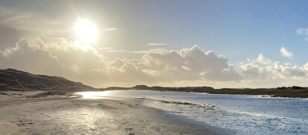 Sonnenlicht über Dünen und Strand – Sinnbild für eine Kraftquelle-Session, um neue Energie zu tanken und innere Balance zu finden.