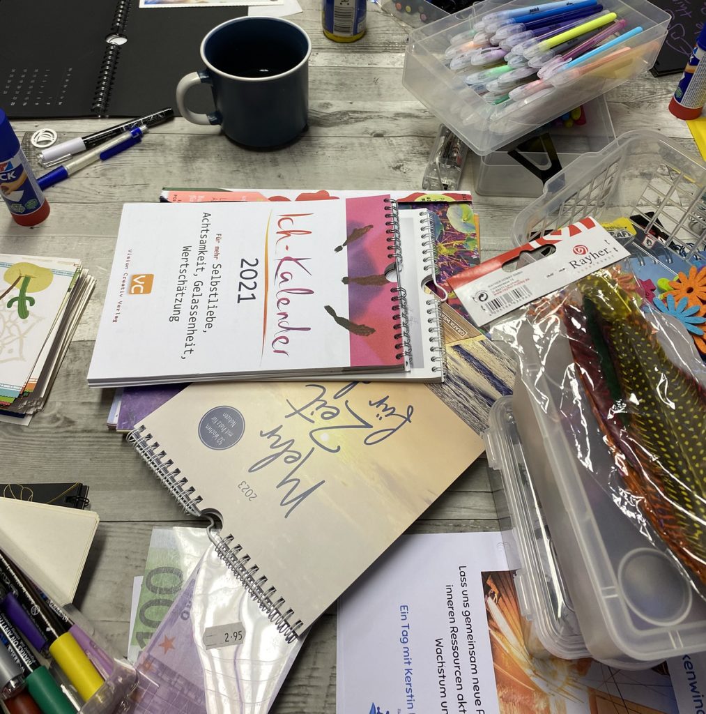 Kreativmaterialien mit Kalendern, Stiften und Bastelutensilien – Symbol für persönliche Anker, Gestaltung und eigene Glückskoffer-Ideen im Workshop.