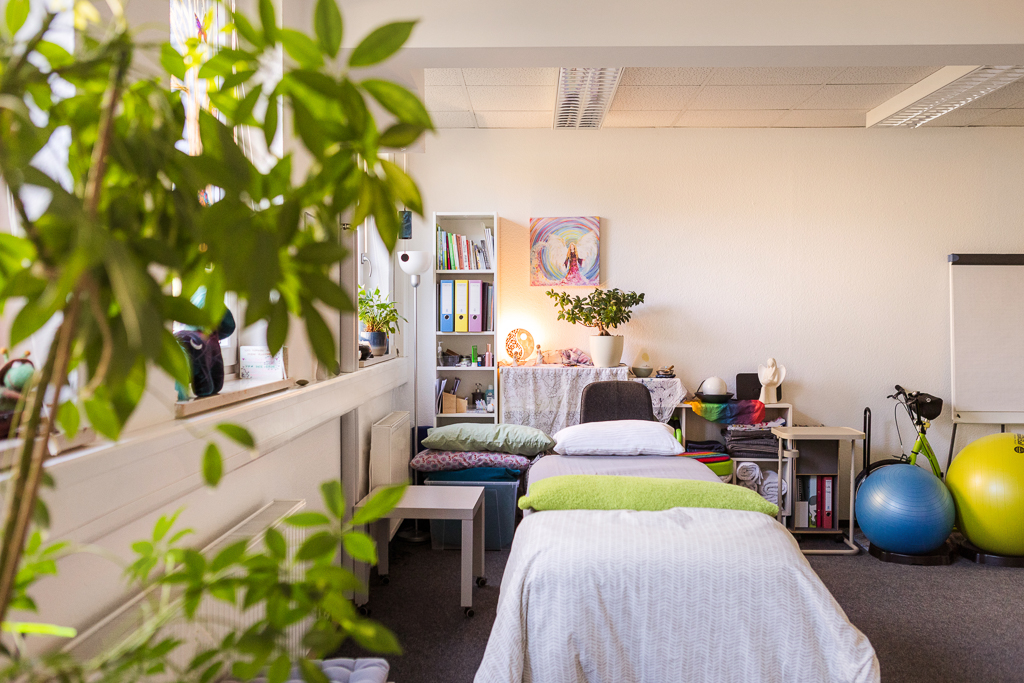 Behandlungsraum für energetische Körperarbeit und Coaching in Nürnberg Heller Praxisraum mit Behandlungsliege, Pflanzen, Gymnastikbällen und ruhiger Atmosphäre für Coaching und energetische Körperarbeit in Nürnberg