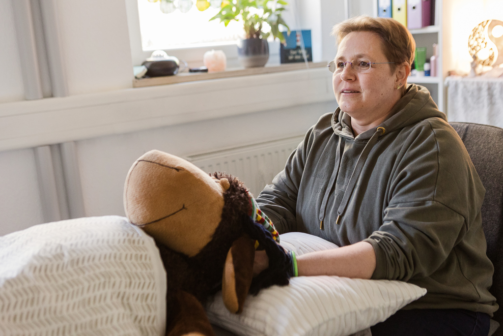 Energetische Begleitung mit Access Bars® – Anwendungssituation in Nürnberg Person bei einer energetischen Access Bars® Session mit Kuscheltier als Symbolbild in ruhiger Praxisumgebung in Nürnberg
