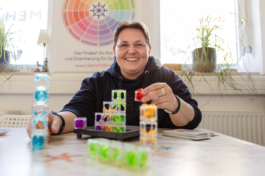 Kerstin Biß demonstriert in einer Beratung mit bunten Bausteinen und einem Modell anschaulich die Zusammenhänge.