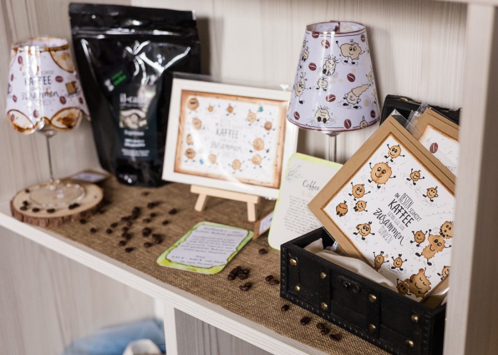 Regal im kleinen Kauflädchen mit Il-caffè Bio aus der Rösterei Rückersdorf, kombiniert mit handgemachten Karten und Lampen als besondere Geschenkidee.