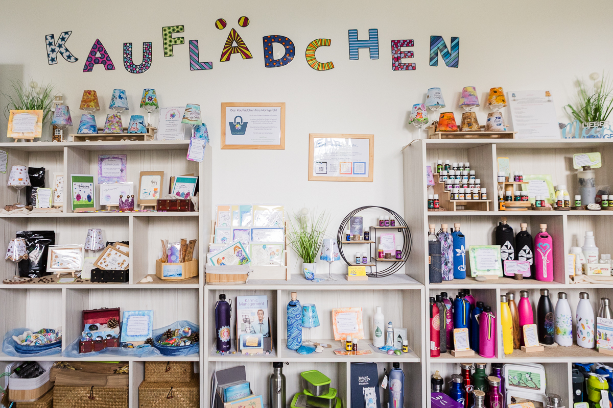 Übersicht des kleinen Kauflädchens mit buntem Schriftzug, handgemachten Lichtinseln, Karten, ätherischen Ölen und nachhaltigen Produkten.