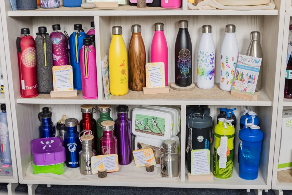 Buntes Flaschensortiment im kleinen Kauflädchen – Dora’s Glasflaschen, ECOtanka Edelstahlflaschen und Blender Bottle Shaker, nachhaltig und BPA-frei