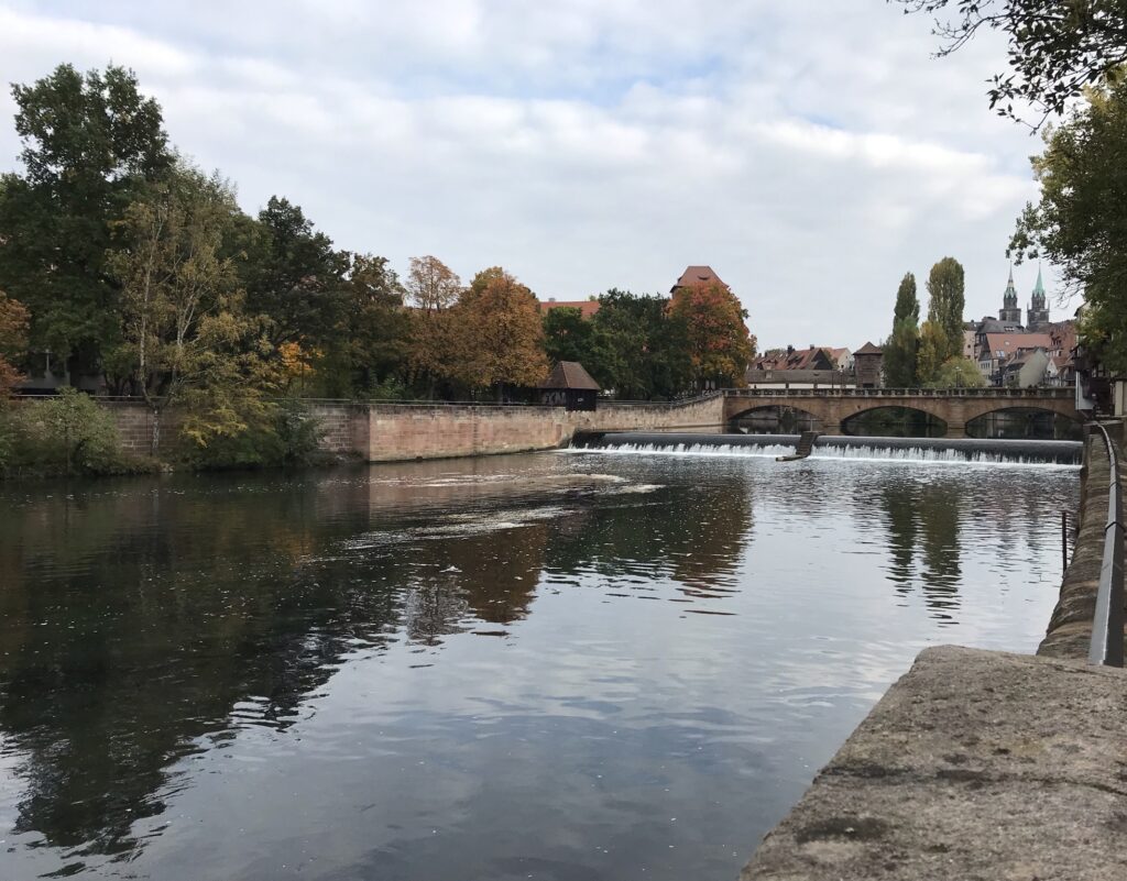 Blick über die Pegnitz mit Brücke, Bäumen und Nürnberger Altstadt